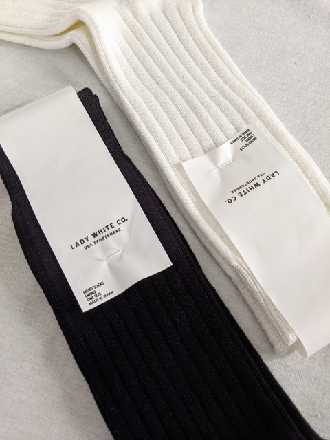 A black pair & a white pair of organic cotton Lady White Co. rib crew socks. Knitted in Japan using vintage japanese knitting machines for MUKAEMUZ